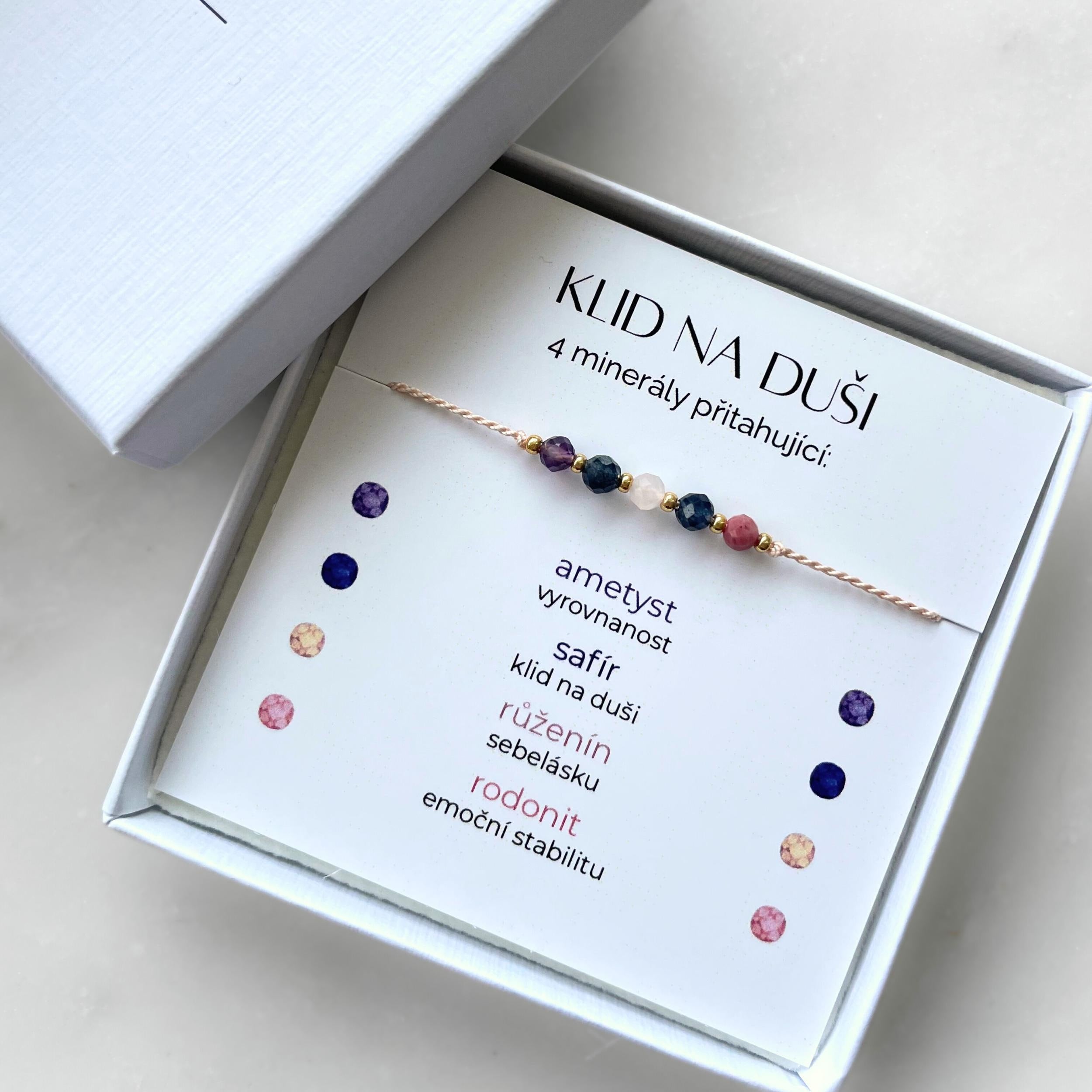 Bílá krabička, ve které je náramek vytvořený z hedvábného provázku a pěti minerály. Náramek je upevněn na promo kartičce s nápisem Klid na Duši. Náramek je udělán na téma Vyrovnanost a Mír. Karta také obsahuje vysvětlivky ke každému použitému kameni: Ametyst pro Vyrovnanost, Safír pro Klid na Duši, Růženín pro Sebelásku, Rodonit pro Emoční Stabilitu