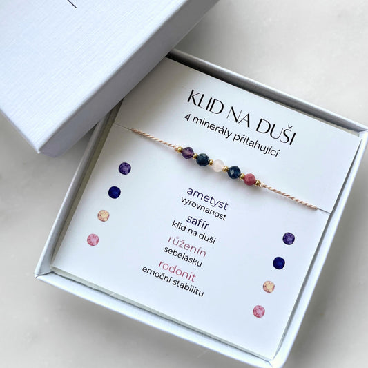Bílá krabička, ve které je náramek vytvořený z hedvábného provázku a pěti minerály. Náramek je upevněn na promo kartičce s nápisem Klid na Duši. Náramek je udělán na téma Vyrovnanost a Mír. Karta také obsahuje vysvětlivky ke každému použitému kameni: Ametyst pro Vyrovnanost, Safír pro Klid na Duši, Růženín pro Sebelásku, Rodonit pro Emoční Stabilitu