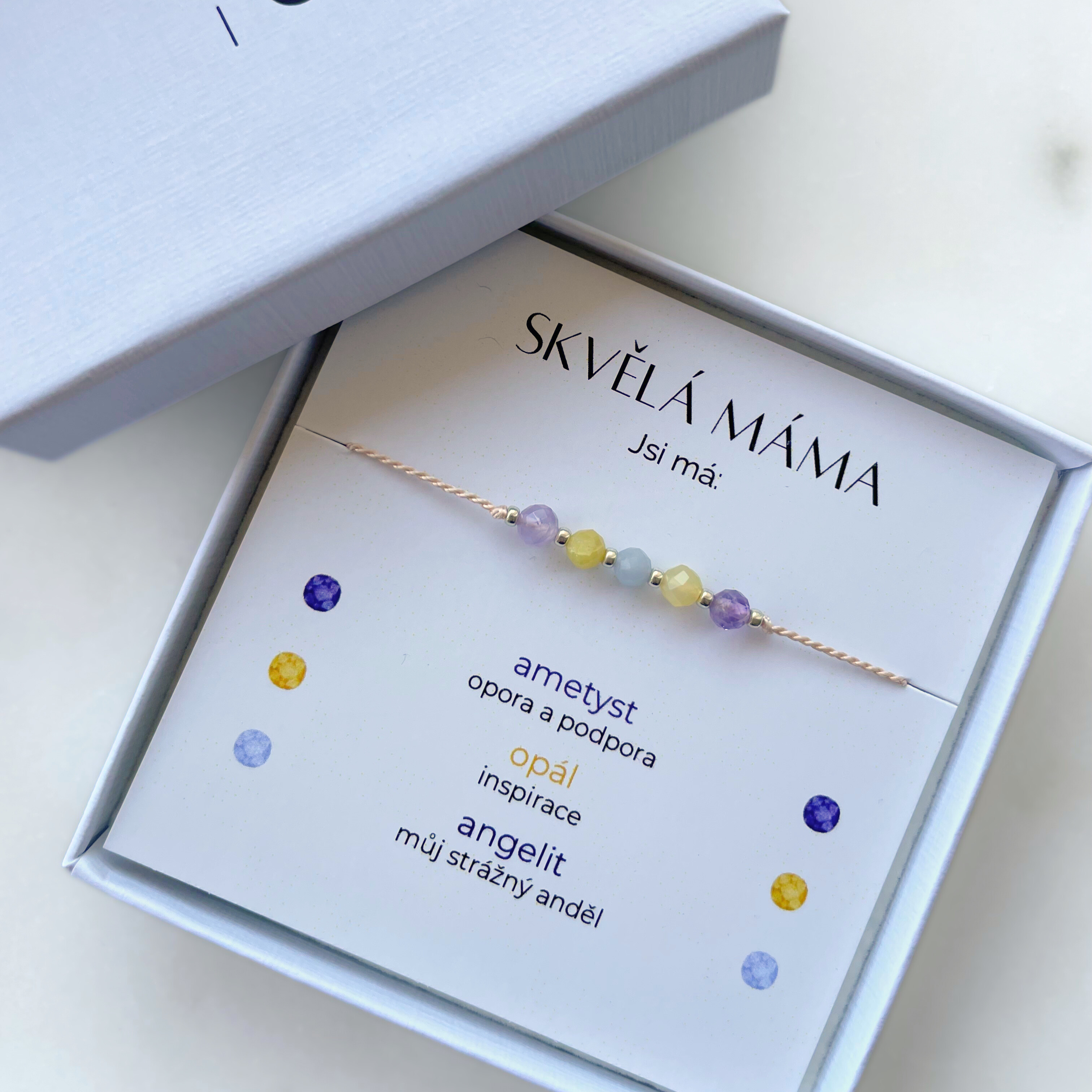 Náramek Skvělá máma ze 3 druhů přírodních minerálů v dárkové krabičce. Karta v balení popisuje symboliku kamenů, které symbolizují co pro vás máma znamená: ametyst opora a podpora, opál inspirace, angelit strážný anděl