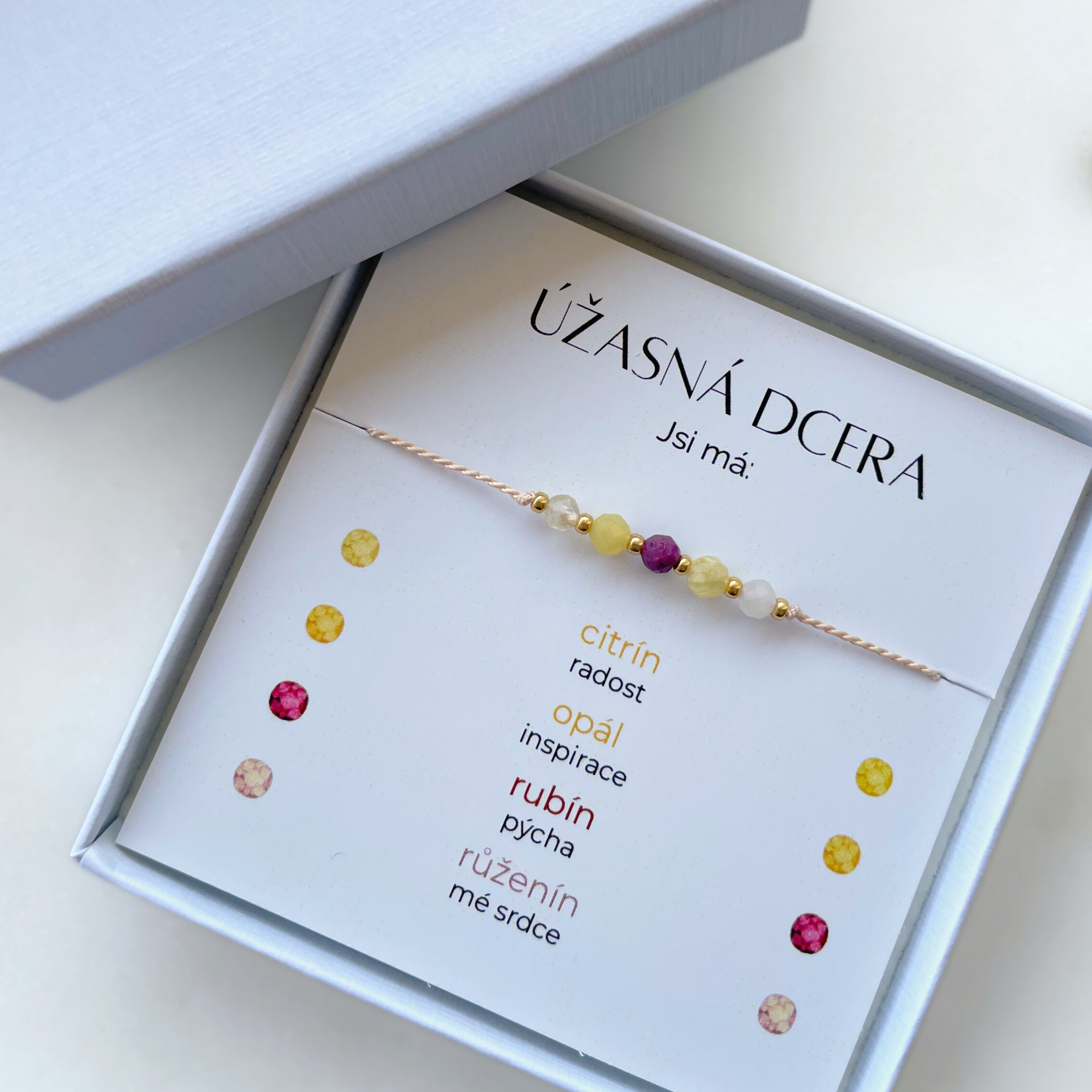 Náramek Úžasná dcera ze 4 druhů přírodních minerálů v dárkové krabičce. Karta v balení popisuje symboliku kamenů, které symbolizují co pro vás dcera znamená: citrín radost, opál inspirace, rubín pýcha, růženín srdce